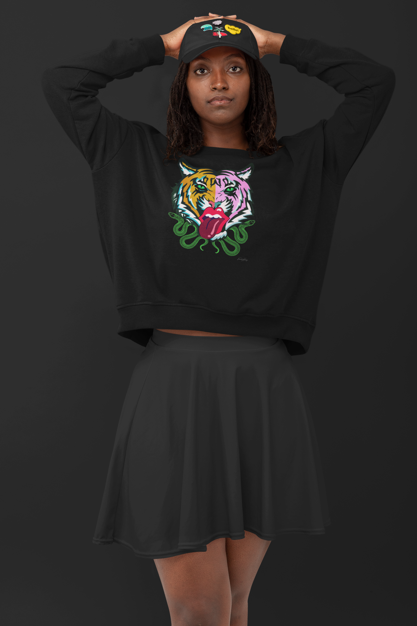 Model wearing Kali unisex drop shoulder sweatshirt with tiger and Rolling Stones tongue design, styled with a skirt and hat.