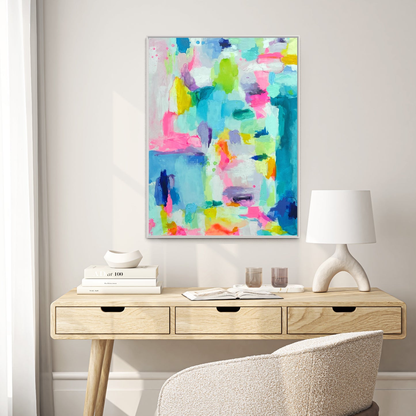 The Dolly Original Abstract Painting by Sarah Henry as part of the Happy Art Collection, shown on a white wall hanging above a three drawer modern desk with monochromatic white decor and a white boucle office chair.