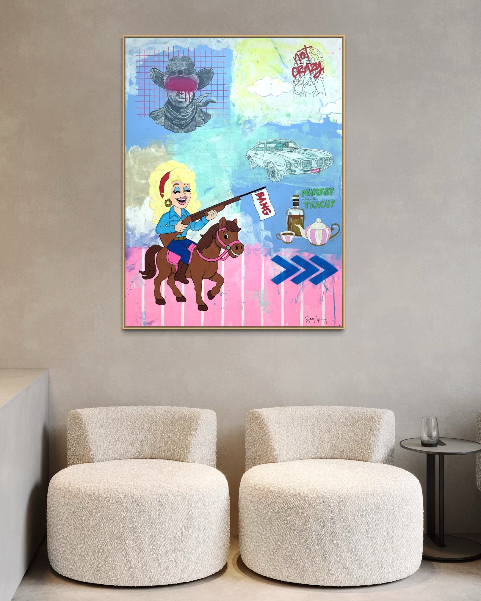 Colorful abstract Dolly Parton painting on a wall above two beige chairs.