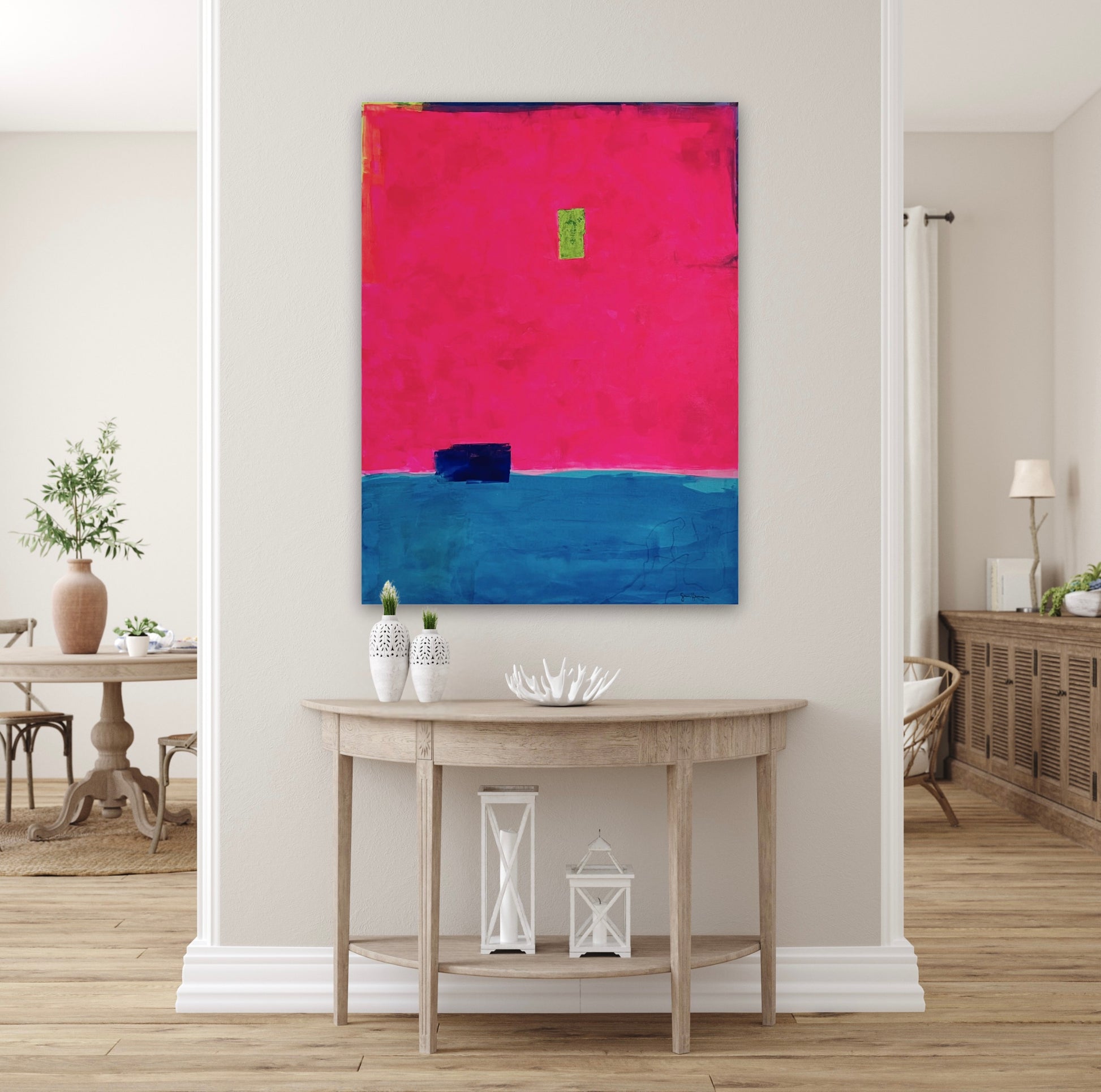 Oversized large abstract art features a bold composition of vibrant fuchsia pink occupying the upper portion and deep blue in the lower section. A small, ultramarine blue rectangular shape sits near the dividing line, while a tiny neon green rectangle is positioned slightly above the center. Along the top, the fluorescent pink stops short of the edge of the canvas, showing a small border of blue, purple, and neon yellow. The 36"x48" original painting hangs on a white wall in a neutral hallway.