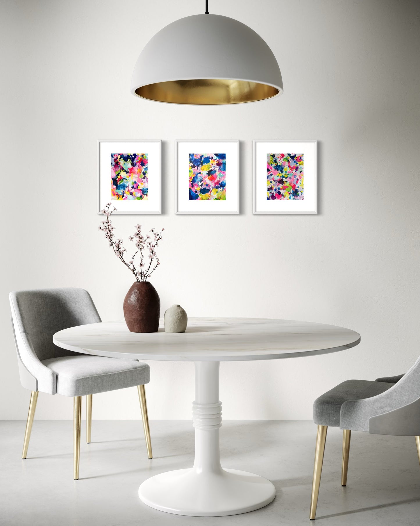 A modern collection of affordable abstract paintings featuring vibrant splashes of color, including pink, blue, yellow, green, purple and white. Each canvas is filled with expressive, energetic brushstrokes and layered paint splatters, creating a dynamic and contemporary composition. The modern wall decor is arranged side by side on a white wall in dining room.
