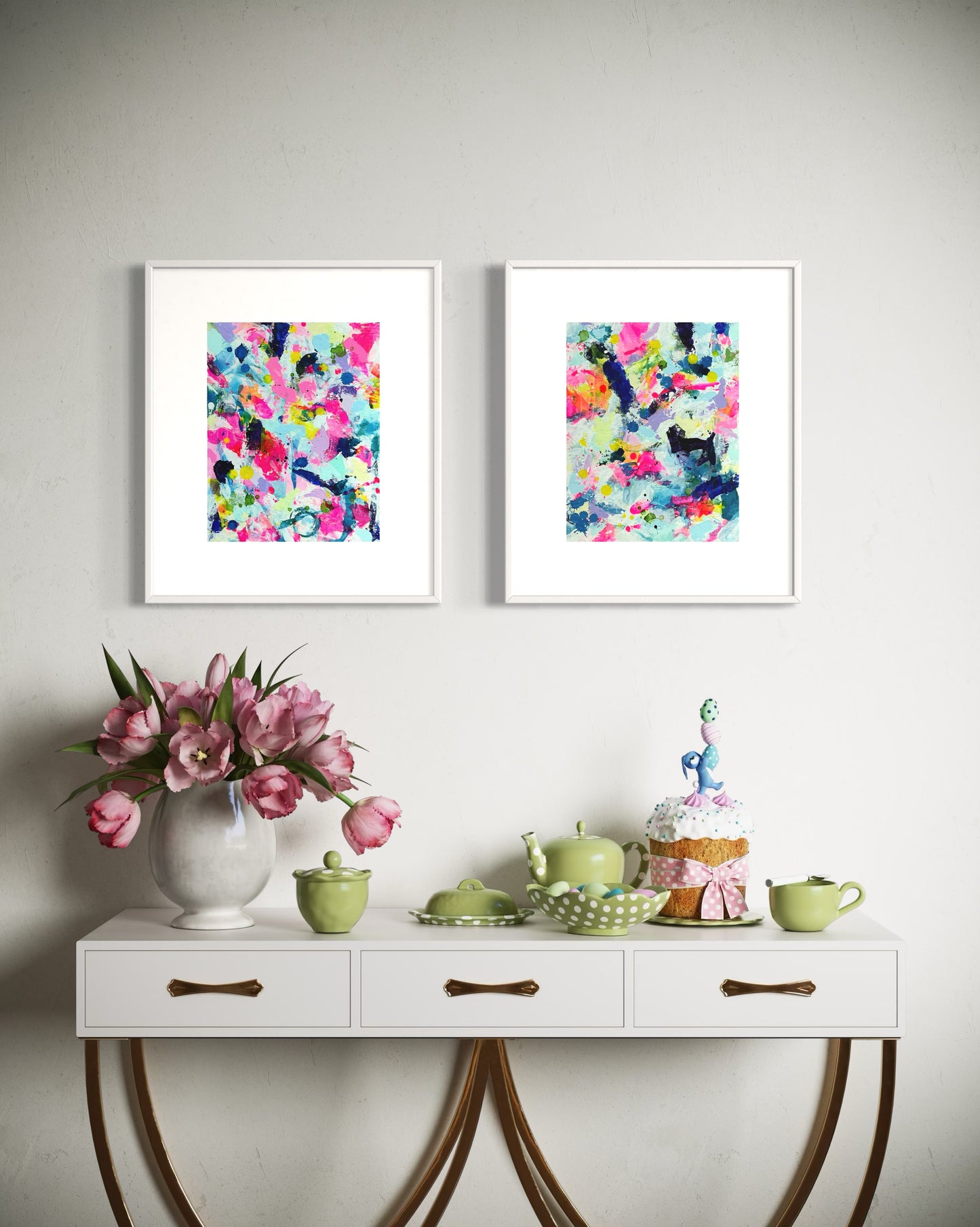 A modern gallery collection of abstract paintings featuring vibrant splashes of color, including pink, blue, yellow, green, purple and white. Each canvas is filled with expressive, energetic brushstrokes and layered paint splatters, creating a dynamic and contemporary composition. The affordable wall decor is arranged side by side on a white wall in a kitchen.