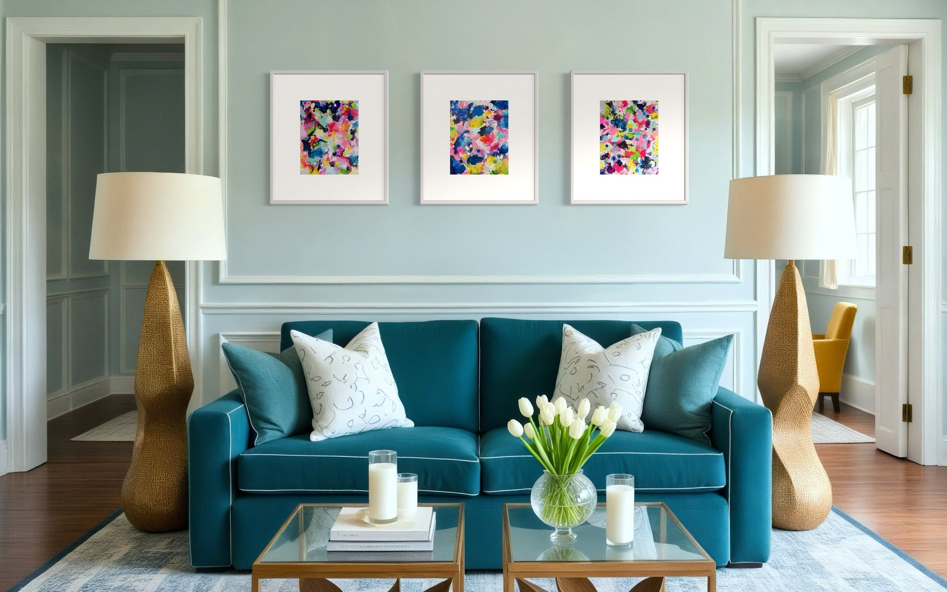 A modern collection of affordable abstract paintings featuring vibrant splashes of color, including pink, blue, yellow, green, purple and white. Each canvas is filled with expressive, energetic brushstrokes and layered paint splatters, creating a dynamic and contemporary composition. The modern wall decor is arranged side by side on a blue wall in living room.