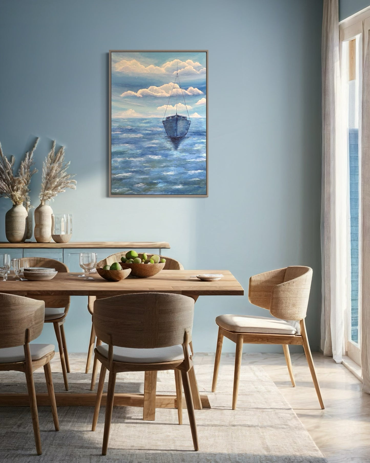 A serene ocean painting of a solitary sailboat floating on calm, deep blue waters. The boat is slightly off center in the composition, with its reflection subtly visible on the water’s surface. The sky above is painted with soft, muted tones of pale blue, white and navy, with expressive brushstrokes forming abstract cloud patterns. The horizon line is faint, blending seamlessly with the sky and sea, creating a tranquil and minimalist atmosphere. The art decor hangs on a blue wall in a dining room.