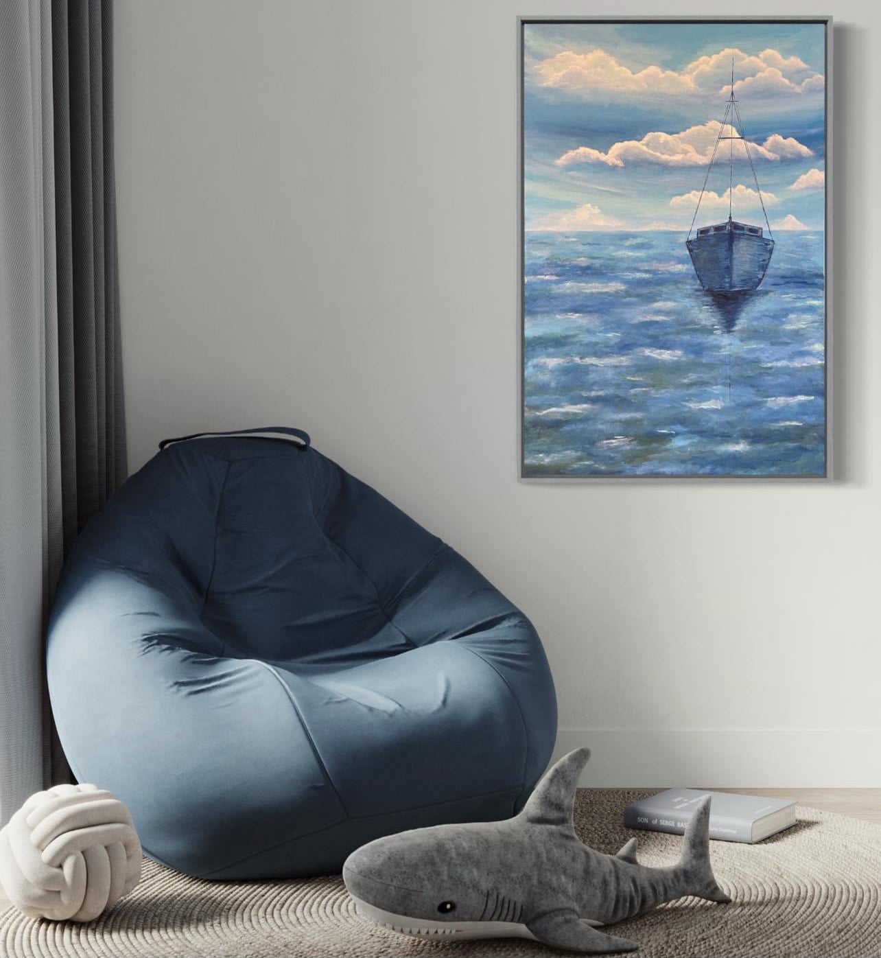 A serene ocean painting of a solitary sailboat floating on calm, deep blue waters. The boat is slightly off center in the composition, with its reflection subtly visible on the water’s surface. The sky above is painted with soft, muted tones of pale blue, white and navy, with expressive brushstrokes forming abstract cloud patterns. The horizon line is faint, blending seamlessly with the sky and sea, creating a tranquil and minimalist atmosphere. The art decor hangs in a nursery playroom bedroom.