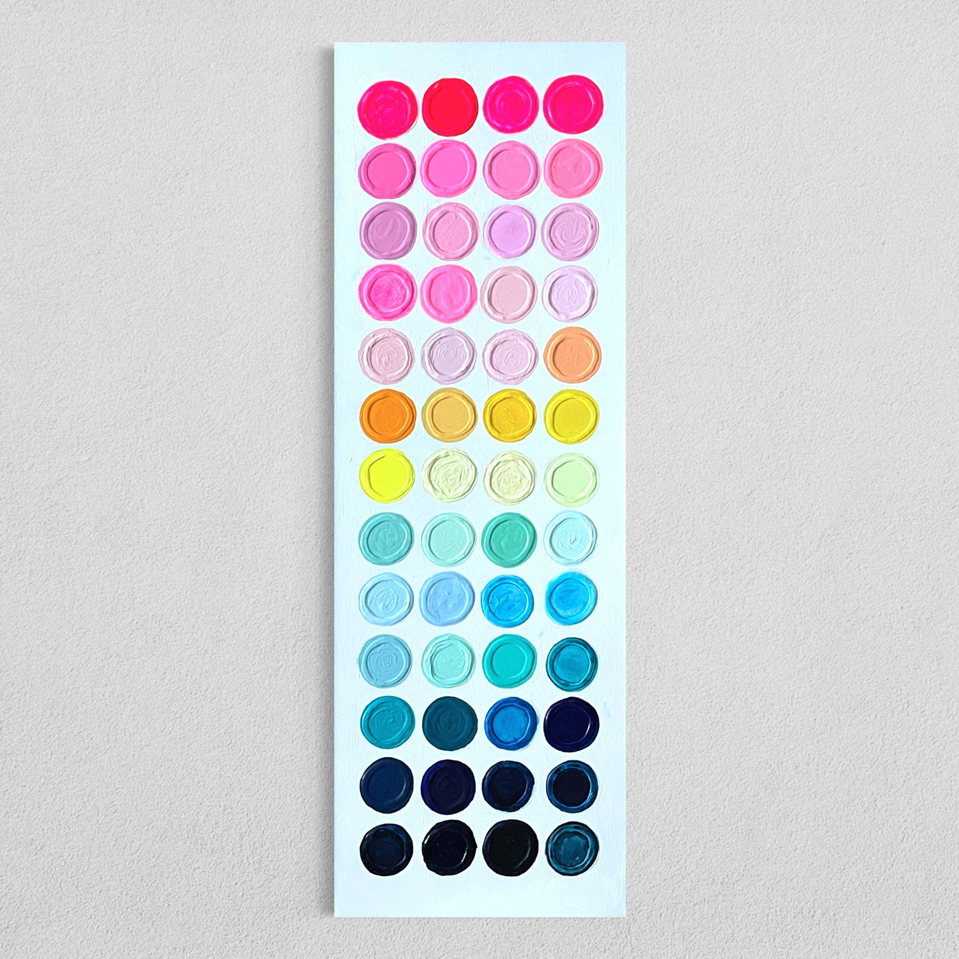 Colorful abstract painting titled Candy Buttons featuring rows of hand-painted, raised acrylic dots arranged in a vertical gradient from hot pinks at the top to deep blues and blacks at the bottom, set on a clean white background.