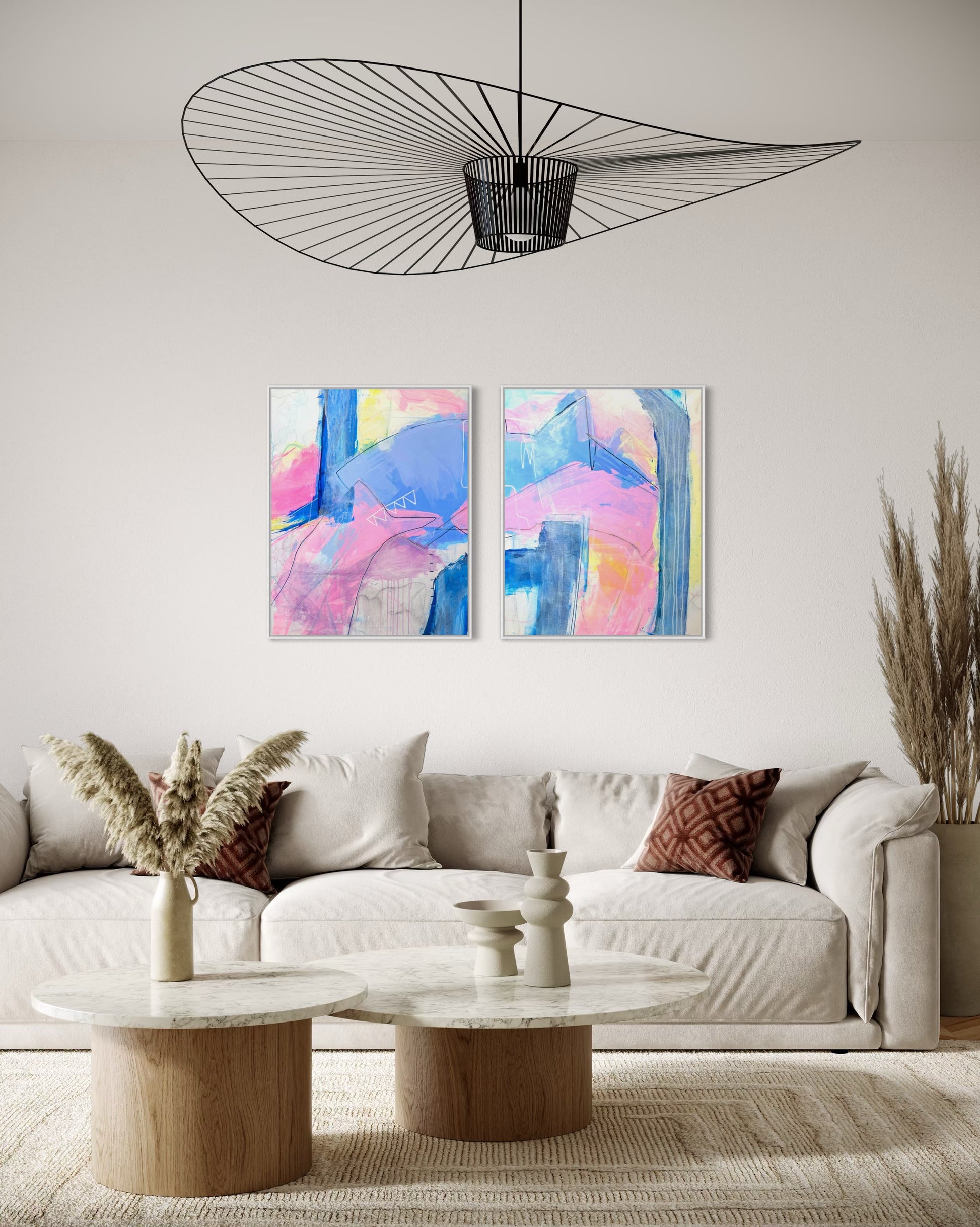"Palm Beach " is a diptych of abstract paintings featuring soft, layered strokes in shades of pink, blue, and yellow. The compositions include geometric and organic shapes with subtle linear details, creating a harmonious and modern aesthetic. This affordable coastal grand millennial decor hangs in a palm beach style living room.