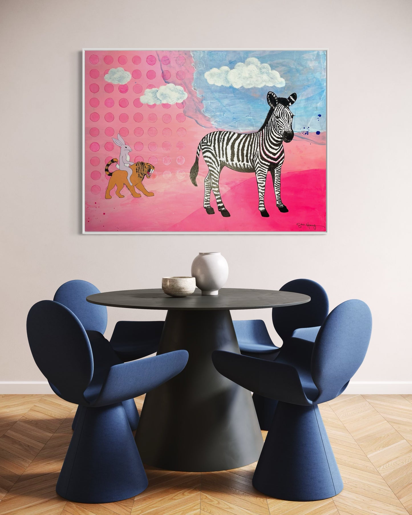 Dining room with a modern table and blue chairs with an expressionism expressionist painting on the wall.