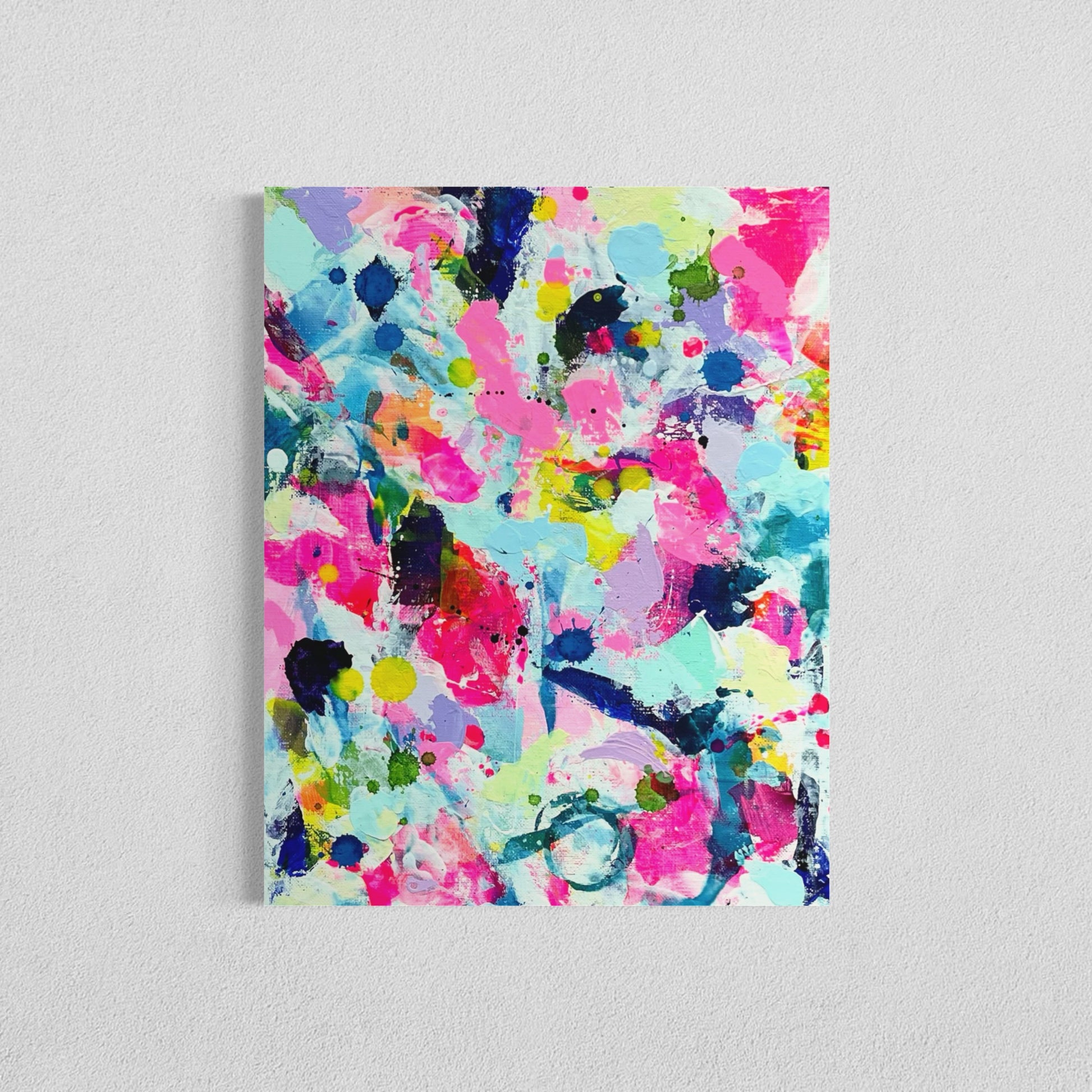 A modern abstract painting featuring vibrant splashes of color, including pink, blue, yellow, green, purple and white. Each canvas is filled with expressive, energetic brushstrokes and layered paint splatters, creating a dynamic and contemporary composition. The affordable wall decor is on a white wall, forming a cohesive yet varied visual experience.