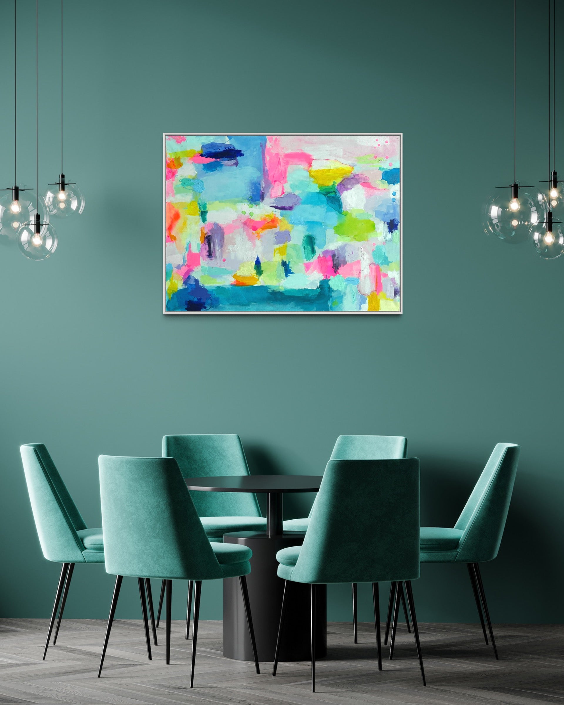 The Dolly Original Abstract Painting by Sarah Henry as part of the Happy Art Collection, shown on a light turquoise green wall above a modern dining set with a round, black dining table and six light turquoise green upholstered dining chairs with two parallel bubble light chandeliers.