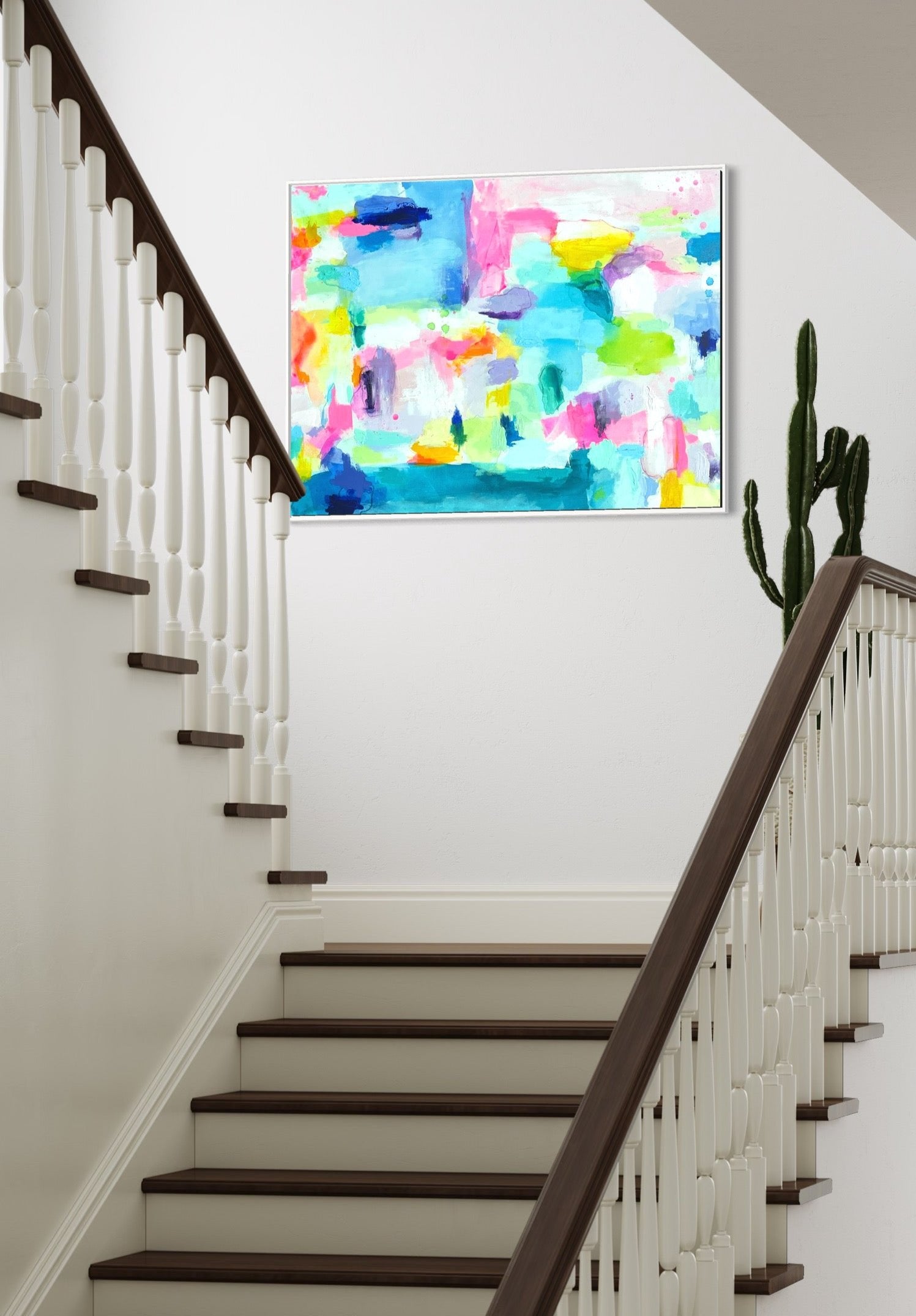The Dolly Original Abstract Painting by Sarah Henry as part of the Happy Art Collection, shown on a white wall of a residential stair landing with a cactus plant beside the painting.