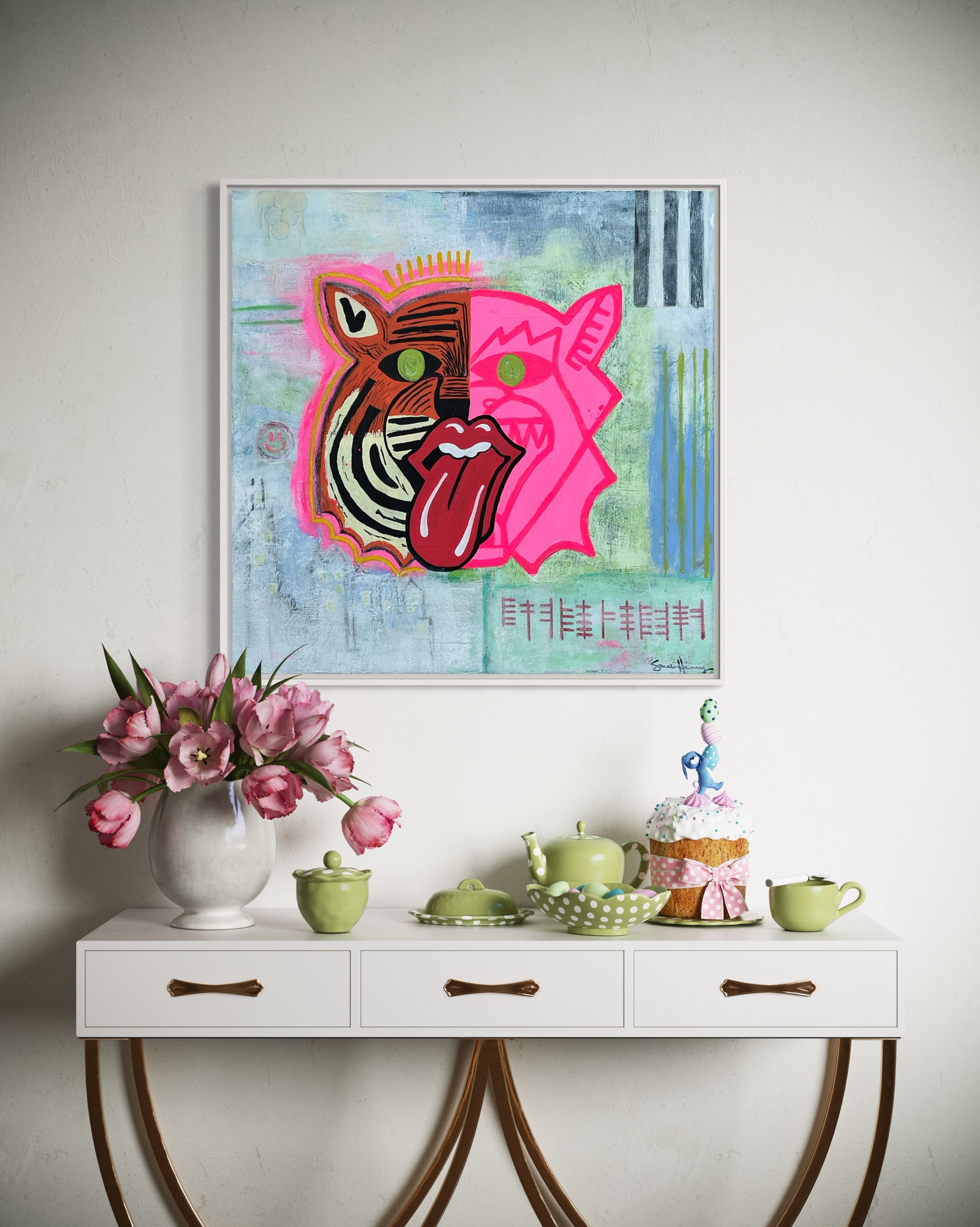 The painting titled Tiger Chewing Consciousness Into Pieces Original Painting by Sarah Henry Art shown hanging on a white wall above a white and walnut wood console table showing a tea party setting, a white vase, and pink open tulips