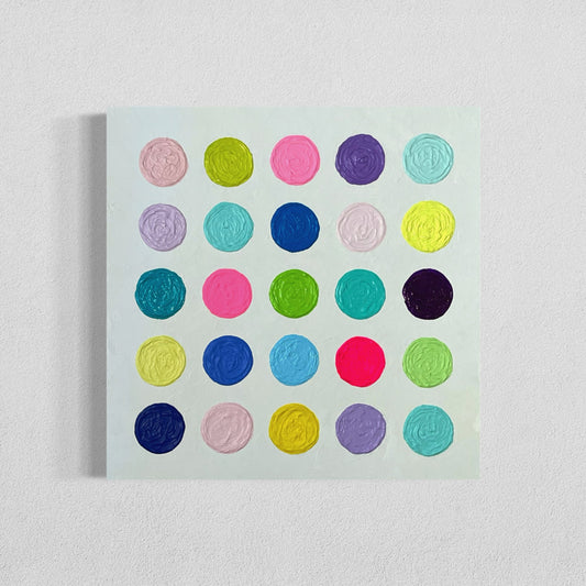 "Cupcakes" is modern contemporary 24x24 inch abstract painting featuring a grid of colorful circles in vibrant shades of pink, green, blue, yellow, and purple. Each circle is heavily textured with swirled patterns, creating a playful and dynamic effect against a crisp white, textured background. The painting is on a stretched canvas with a 7/8" traditional profile. It hangs on a white wall. This wall decor is part of the Happy Art Collection by Sarah Henry.