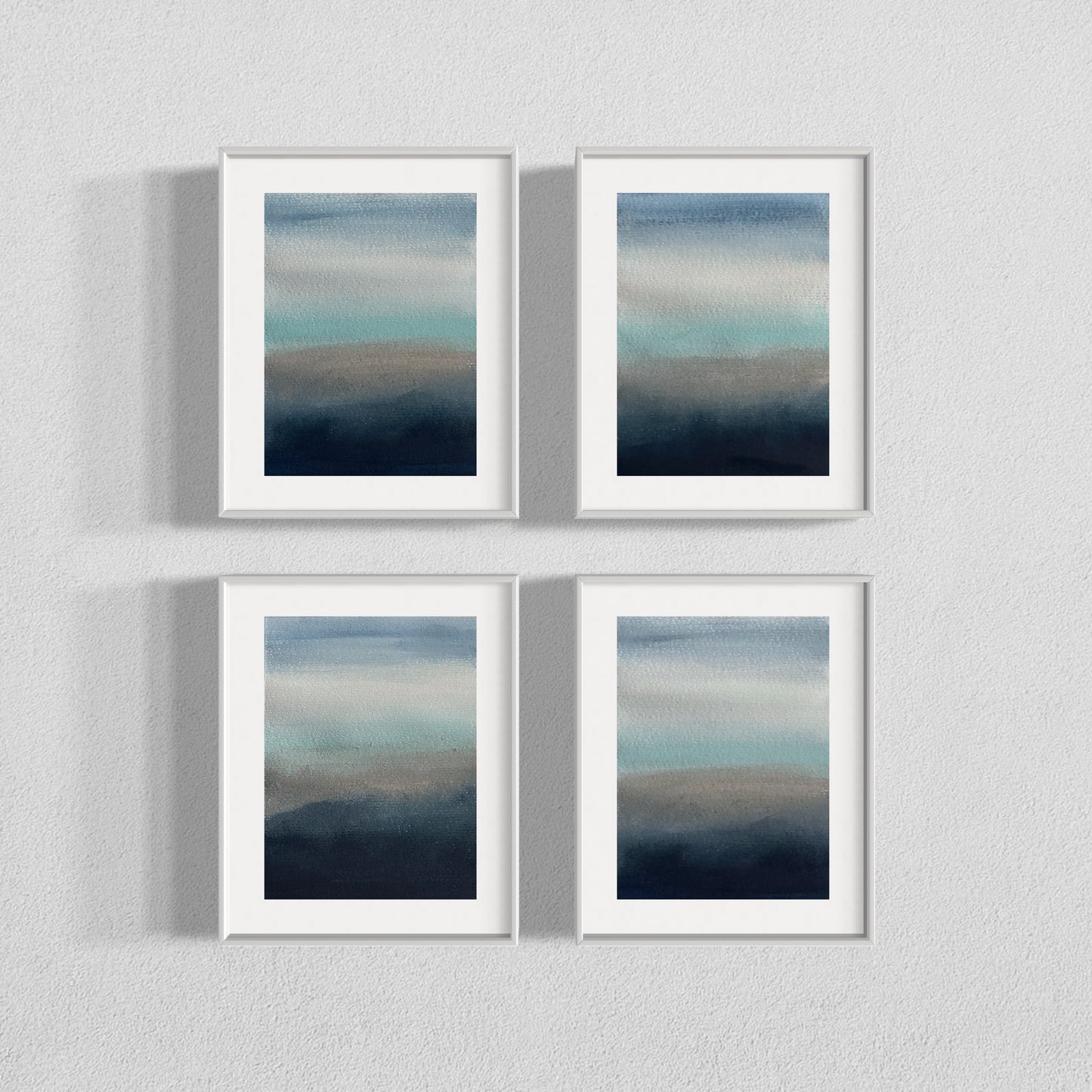 Four framed watercolor paintings with soft gradients of blue, gray, and teal tones.