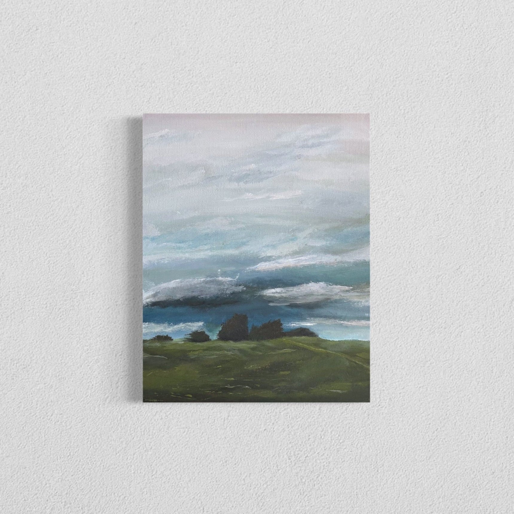 Canvas print of a landscape with green fields and a blue sky.