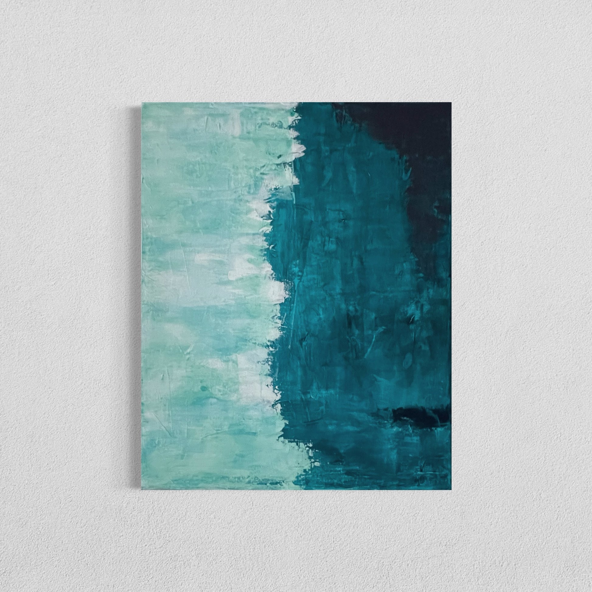 Abstract painting titled "Crashing Waves" featuring a vertical division between soft seafoam green on the left and deep teal-blue on the right, evoking the meeting of ocean waves and shoreline.