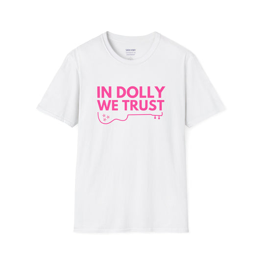 A white dolly parton shirt with pink letters saying In Dolly We Trust
