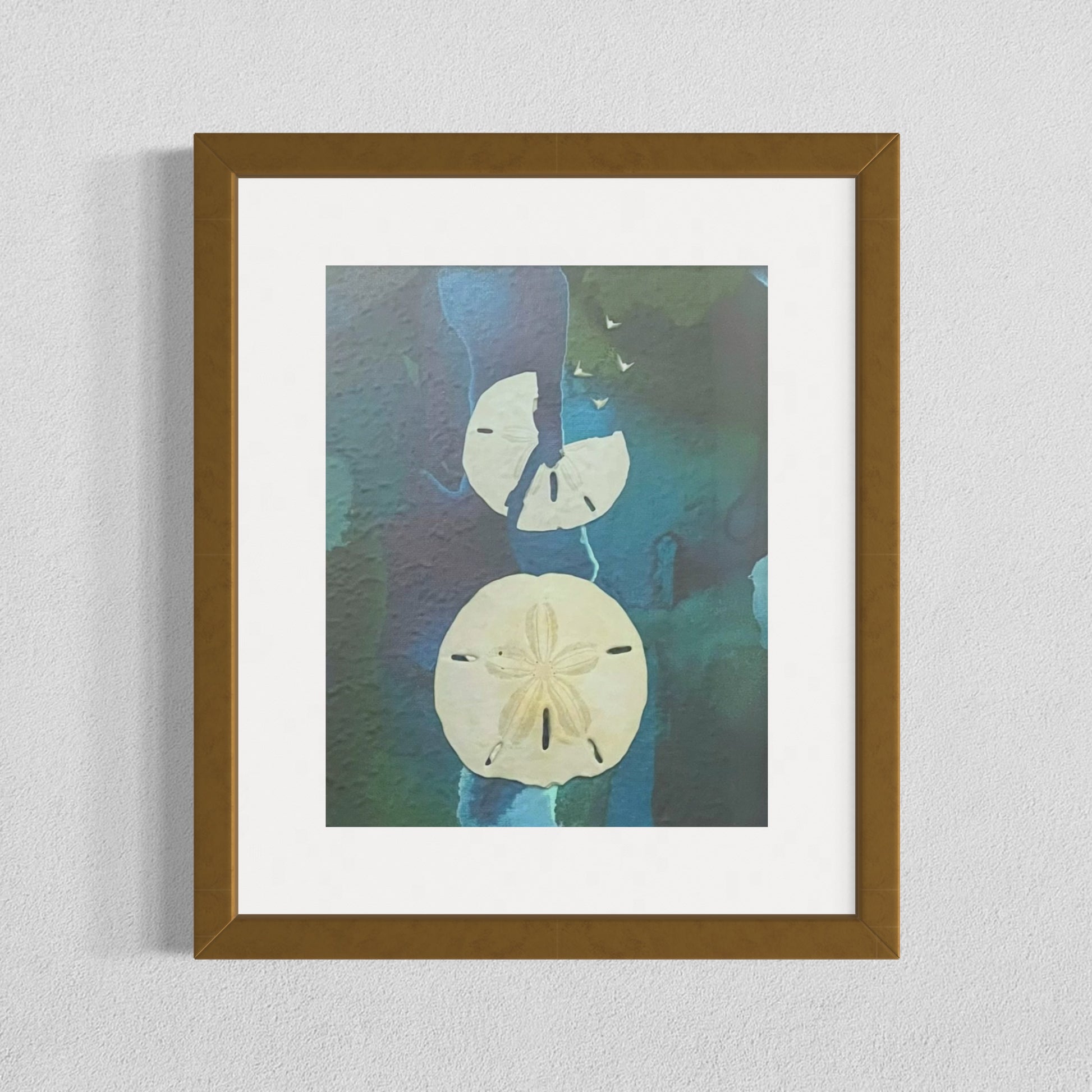 Framed mixed media artwork titled "Free Birds" featuring real sand dollars on an abstract blue and green ink background, with five white bird shapes emerging from a broken sand dollar.
