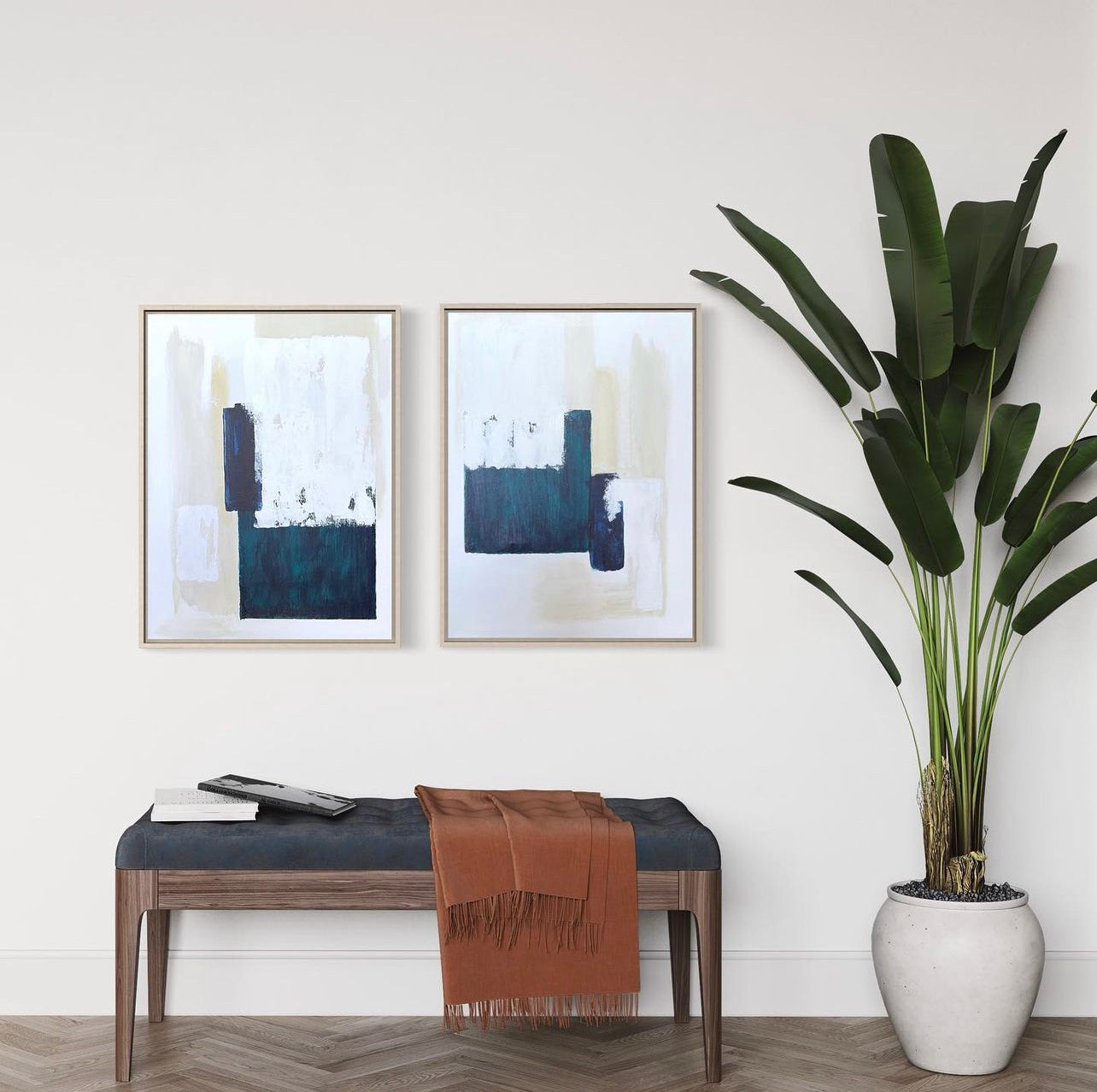 Modern interior with abstract beige and tuquoise diptych art, navy upholstered bench, and palm tree